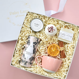 Christmas luxury gift box the pink clementine. includes hot chocolate by The Chocolatier, Hobo and Co soy wax candle, Bramblewood bath fizzy, Bramblewood handmade bar of soap, Keith Brymer Jones National Trust pink mug and seasonal decoration. All small business British gifts